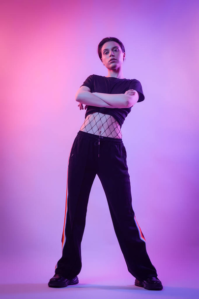 Warrior woman in Pink Blue neon light, Trendy fashionable Hairstyle. High Fashion. Cinematic night portrait of woman  pants and t-shirt in  neon lights - Foto, Imagem