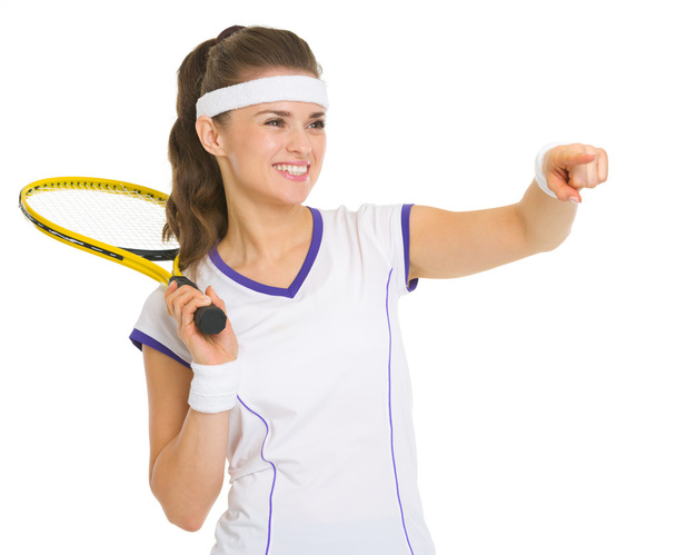 Smiling female tennis player with racket pointing on copy space - Фото, изображение