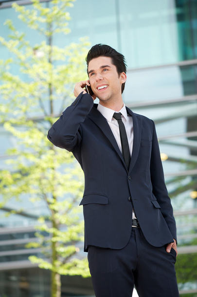 Бізнесмен спілкується на мобільному телефоні на відкритому повітрі
 - Фото, зображення