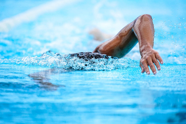 Details mit einem professionellen Athleten, der in einem olympischen Schwimmbecken schwimmt - Foto, Bild