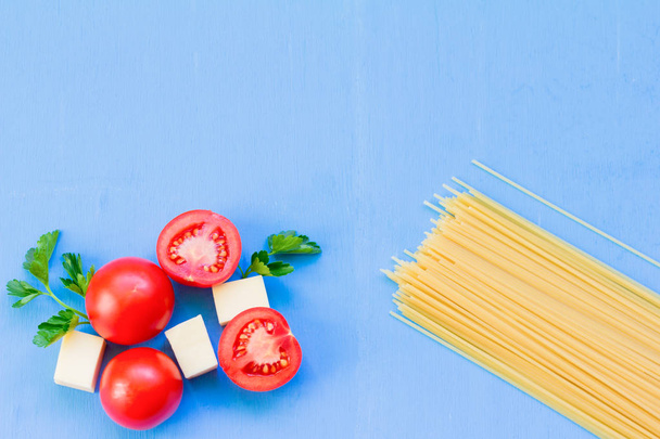 spaghetti and cooking ingredients on blue wooden background - Photo, Image
