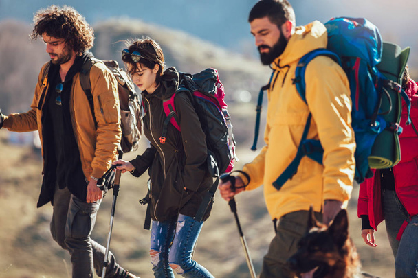 Группа туристов, идущих по горе осенним днем
  - Фото, изображение