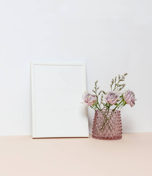 Біла рамка з трьома рожевими трояндами на столі
 - Фото, зображення
