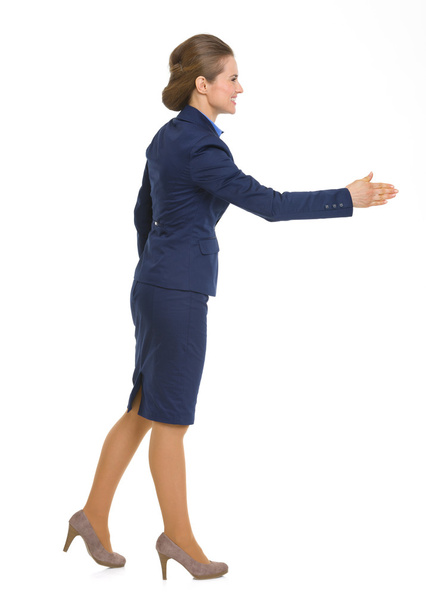 Full length portrait of happy business woman stretching hand for - Zdjęcie, obraz