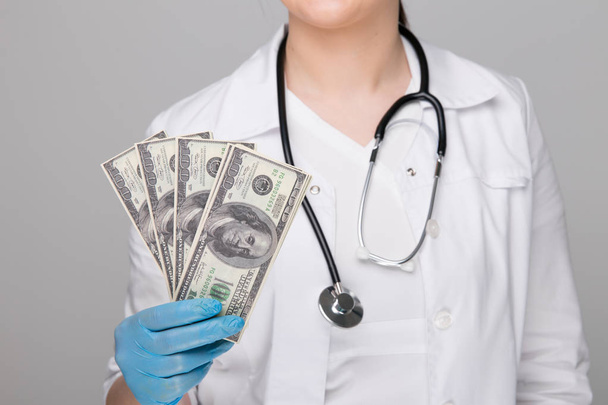 Un retrato de un médico varón con dinero en el bolsillo aislado sobre fondo blanco - Foto, imagen
