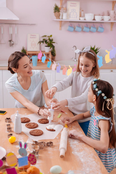 Joyful females decorating cookies together with pleasure - 写真・画像