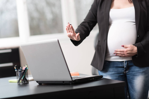 Измученная беременная женщина перед своим ноутбуком
 - Фото, изображение