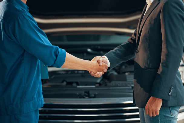 car service workshop garage, mechanic and customer shaking hands  - Foto, afbeelding
