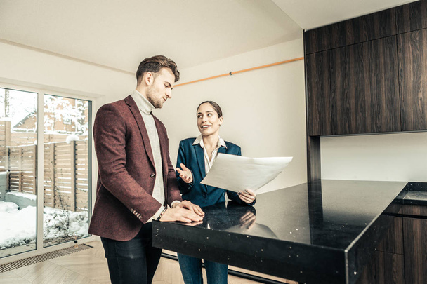 Businessman and realtor standing in the kitchen of his future house - Valokuva, kuva
