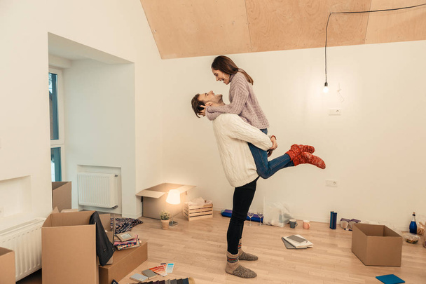 Strong husband lifting his slim beautiful wife while feeling happy - 写真・画像