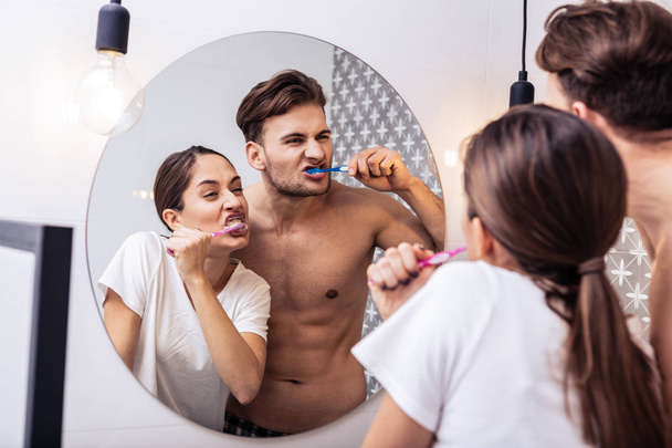 Just married couple making funny faces brushing teeth together - Fotoğraf, Görsel