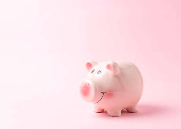 Piggy bank on pink background. Saving money concept. - Foto, afbeelding