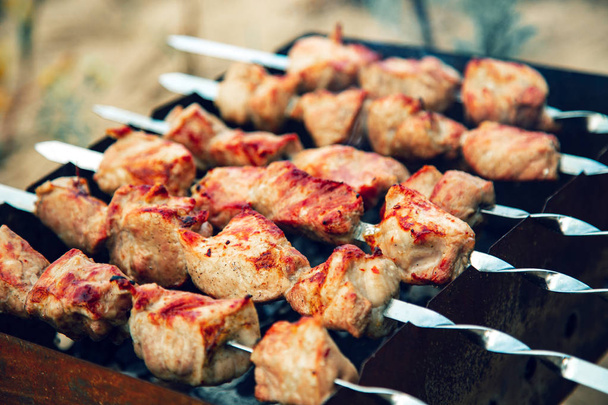Meat skewers being grilled in a barbecue - Фото, зображення