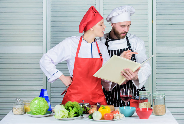 Culinary family concept. Couple in love cooking healthy recipe. Amateur cook read book recipes. Improve cooking skill. Book recipes. Helpful culinary book. Woman chef and man cooking food together - Photo, image