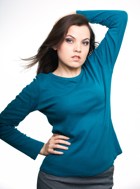 Attractive young woman in a blue shirt and gray skirt. Hair in m - Foto, imagen