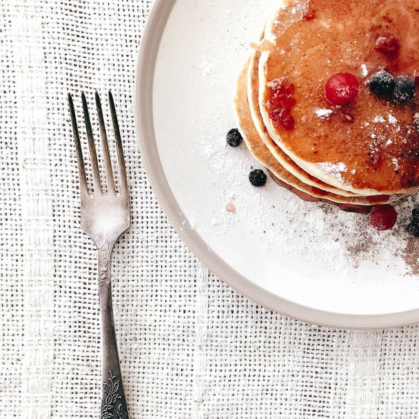 Delicious pancakes with syrup and berries on stylish plate on ru - Fotografie, Obrázek