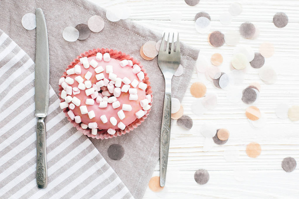 Heerlijke kleurrijke roze donut met hagelslag en marshmallows op - Foto, afbeelding