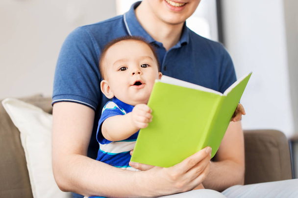 happy father and little baby son with book at home - 写真・画像