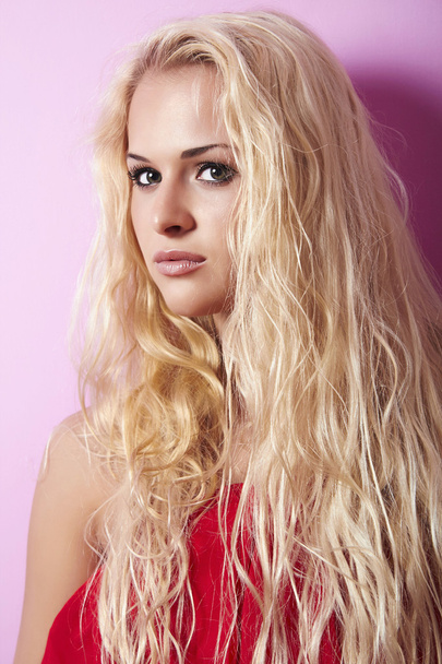 Beautiful blond woman with long hair. pink background - Photo, Image