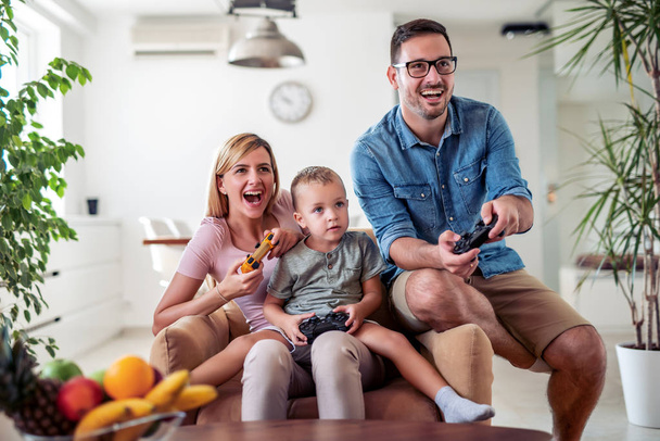 ビデオ ゲームを一緒に遊んで幸せな家族. - 写真・画像
