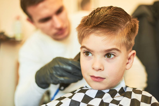 Часткове зображення чоловічої перукарні, що робить стрижку маленького хлопчика в салоні
 - Фото, зображення