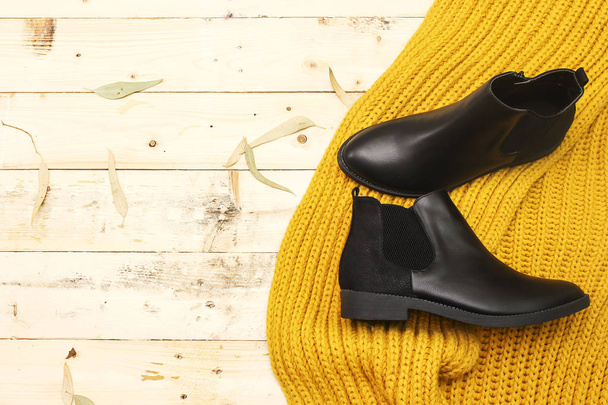 Conjunto de ropa de otoño, invierno de las mujeres sobre un fondo claro botas negras y bufanda. Ropa de moda para paseos, cama plana
 - Foto, imagen