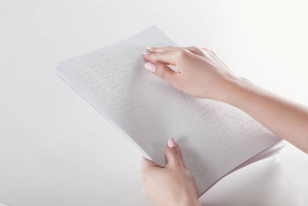 cropped view of young woman reading braille text with hand on white paper - Фото, зображення