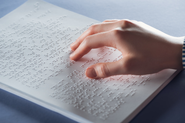 κλείνω πάνω θέα νεαρής γυναίκας ανάγνωσης braille κειμένου με το χέρι - Φωτογραφία, εικόνα