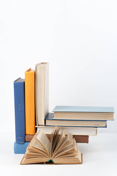 Open book, hardback colorful books on wooden table, white background. Back to school. Copy space for text. Education business concept - Foto, afbeelding