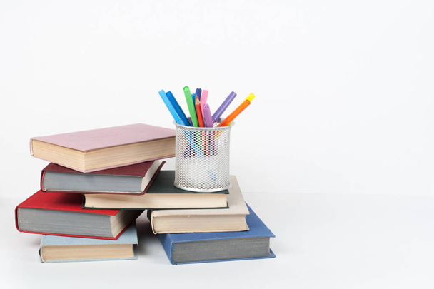 Open book, hardback colorful books on wooden table, white background. Back to school. Copy space for text. Education business concept - Φωτογραφία, εικόνα