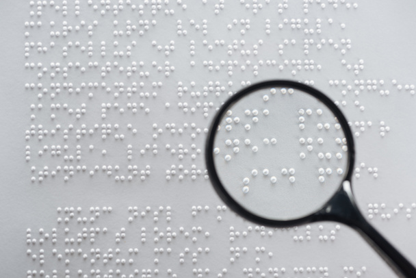 vista superior del texto braille sobre papel blanco con lupa
 - Foto, imagen