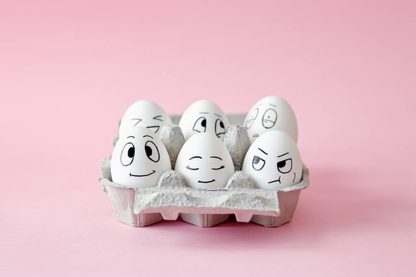 Funny Easter eggs with facial expressions. Eggs with different faces in egg carton.  - Foto, imagen