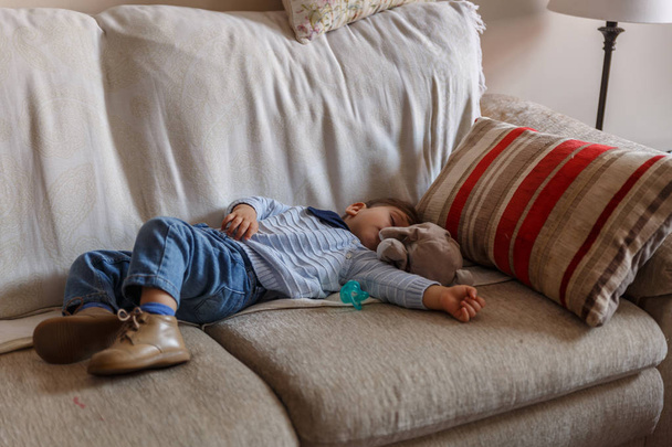 Sevimli çocuk onun hous oturma odasında kanepede barışçıl dayanıyor - Fotoğraf, Görsel