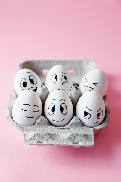Funny Easter eggs with facial expressions. Eggs with different faces on pink background.  - Foto, afbeelding