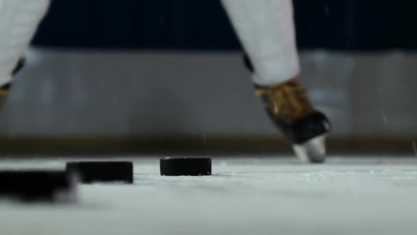 Primer plano del disco en el hielo y el jugador de hockey golpea el disco en cámara lenta
 - Imágenes, Vídeo