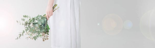 πανοραμικό σφηνάκι κορίτσι στο φόρεμα κρατώντας λουλούδια σε λευκό - Φωτογραφία, εικόνα