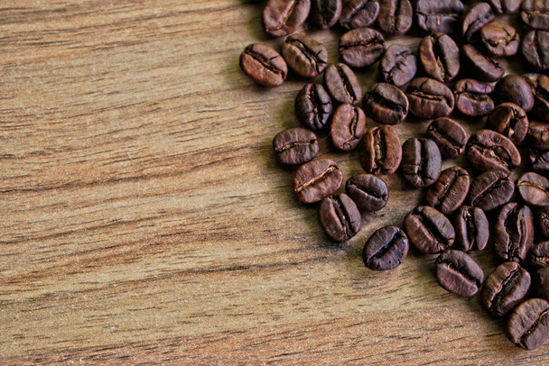 Крупним планом кавові зерна на дерев'яному столі
 - Фото, зображення