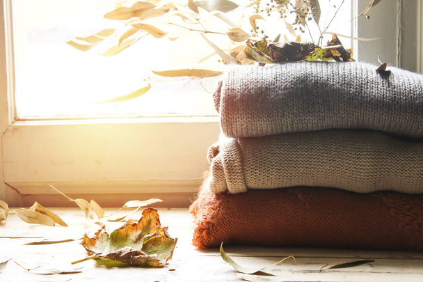 Hola tarjeta de otoño. Bodegón de otoño. suéteres de colores y hojas de arce sobre fondo de madera. el concepto de otoño acogedor
. - Foto, Imagen