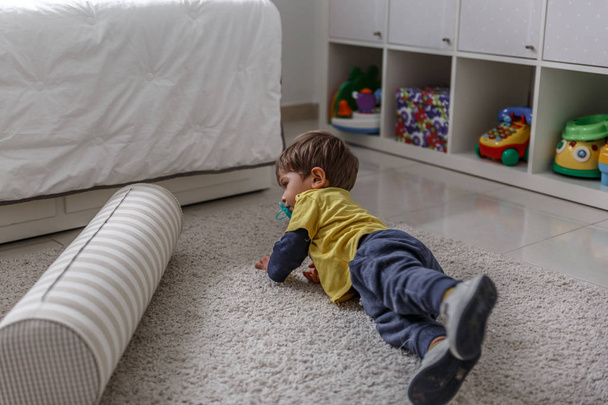 A beautiful child plays and enjoys with his toys in his bedroom - Foto, Imagem