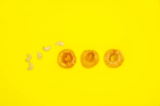 frutos secos pêssego e caju em um fundo amarelo
 - Foto, Imagem
