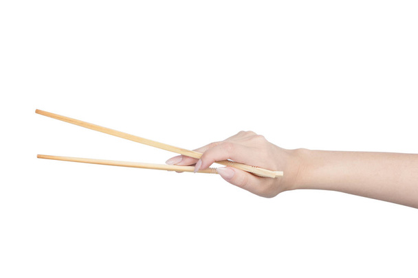 Female hand holding wooden chopsticks - Photo, Image