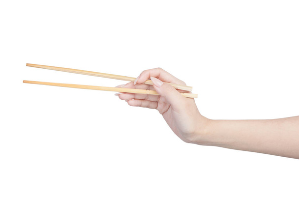 Female hand holding wooden chopsticks - Foto, imagen