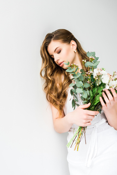 attractive young woman holding bouquet of flowers on white - Foto, immagini