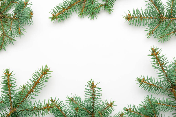 Святкова рамка різдвяних декоративних ялинових гілок на білому тлі, вид зверху, плоский лежак
. - Фото, зображення