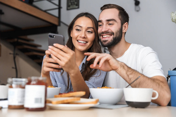 Happy multiethnic couple having breakfast - Фото, изображение