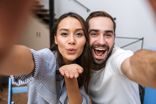 Cheerful multiethnic couple taking a selfie - Foto, immagini