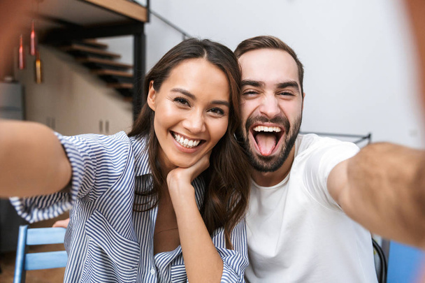 Cheerful multiethnic couple taking a selfie - 写真・画像