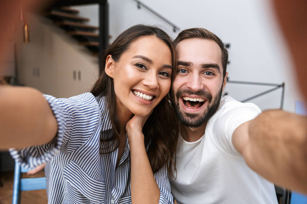 Cheerful multiethnic couple taking a selfie - Foto, afbeelding