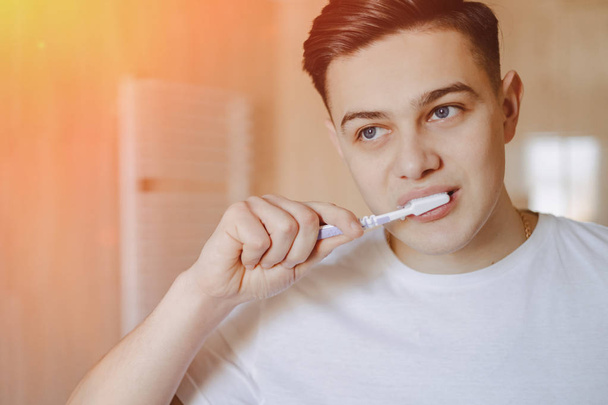 утренняя гигиена, мальчик чистит зубы возле зеркала
 - Фото, изображение