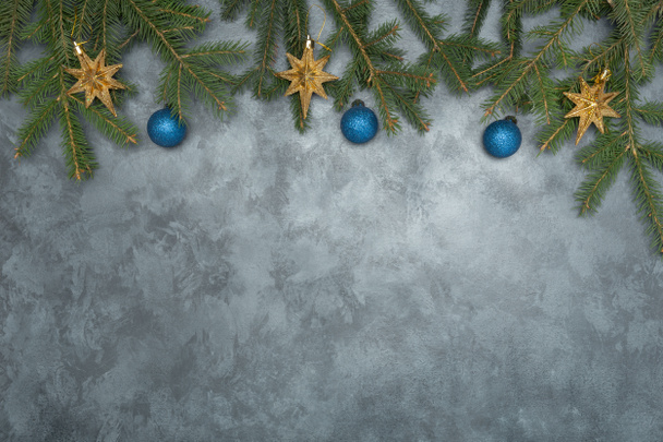 Weihnachtsanordnung aus Tannenzweigen mit Kugeln und Sternenkugeln auf Grunge-Hintergrund - Foto, Bild